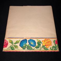 an old cloth with flowers on it is laying on a black tablecloth that has been embroidered onto