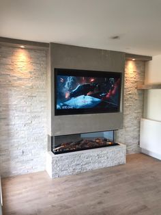 a flat screen tv mounted on the wall above a fireplace