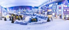 the inside of a mall with snow on the ground and christmas trees in the background