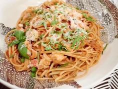 a white bowl filled with pasta covered in sauce and garnished with parmesan cheese