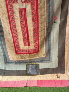 an old quilt hanging on the wall next to a chalkboard with writing on it