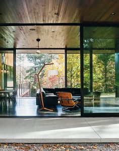 the inside of a modern house with glass walls and sliding doors that lead to an outside deck