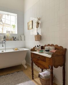 a white bath tub sitting next to a wooden table