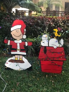 two cardboard christmas decorations in the grass