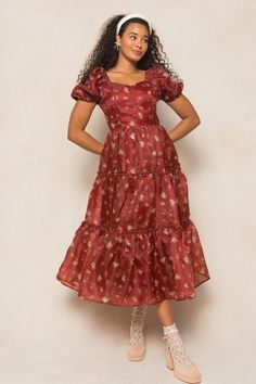 Get ready to dance the night away in our Ever After Dress in Red! Made from maroon organza fabric with multicolored florals, this midi-length dress features a sweetheart neckline and short puff sleeves with elastic closures. The ruffle tiered skirt adds a touch of playful flair, while corset boning on the bodice and a functional tie closure on the back provide a flattering fit. Fully lined for comfort. Short Sleeve Organza Dresses For Garden Party, Organza Short Sleeve Dress For Garden Party, Organza Dresses For Garden Party, Red Tiered Dress For Garden Party, Burgundy Midi Dress With Short Sleeves For Summer, Red Fitted Tiered Midi Dress, Red Short Sleeve Midi Dress With Ruffles, Fitted Red Tiered Midi Dress, Fitted Tiered Red Midi Dress