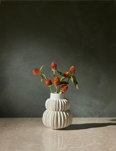 a white vase filled with flowers on top of a table