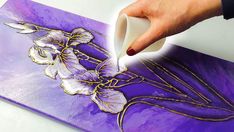 someone is painting flowers on a purple surface