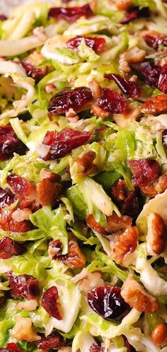 lettuce salad with cranberries and pecans in it, ready to be eaten