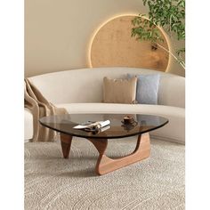 This coffee table draws inspiration from the iconic 1950s design crafted by the renowned poet and sculptor, Isamu. The classic smooth curves are a testament to Isamu's defiance of conventional straight lines, embodying a sense of artistic rebellion. Our reproduction captures the essence of elegance and simplicity that this coffee table is celebrated for, making it a fitting addition to any contemporary home or workspace. Wrought Studio™ Table Base Color: Walnut | Wrought Studio™ Holderman Glass Irregular Coffee Table, Coffee Table Small Space, Nyc Dream, Triangle Coffee Table, Modern Wood Coffee Table, Living Room Center, Mid Century Modern Coffee Table, Glass End Tables, Table For Small Space