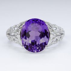 This vintage style ring features an amethyst set in a sterling silver setting. The Art Deco style setting is beautifully crafted with flower accents and curling filigree details. The oval amethyst is a natural, earth mined stone. The ring measures 12mm across (north south) and 8.5mm from finger to top. Please note that colors can vary slightly depending on your monitor and display settings. The video features this setting with a swiss blue topaz center. This version is also available in our shop Amethyst Set, Vintage Style Rings, Art Deco Stil, Amethyst Color, Purple Band, North South, Sterling Silver Filigree, Swiss Blue Topaz, Natural Earth