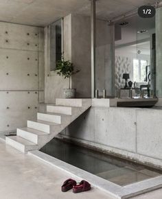 a pair of red shoes sitting on the ground in front of a staircase leading up to a bathroom