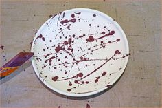 a white plate with brown paint splattered on it