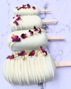 three white chocolate pops with flowers on them