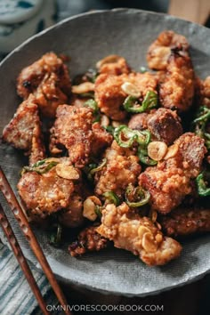 a plate full of fried food with chopsticks on the side and sauce in it