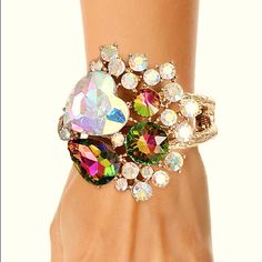 A Full Heart Textured Gold Metal Hinge Closure Cuff Bracelet Featuring Heart, Round And Teardrop Aurora Borealis Crystals With Rhinestone Accents. Detail Measures 2.5 Inches. Glamorous Crystal Cuff Bracelet For Party, Elegant Heart-shaped Crystal Bracelet For Parties, Heart-shaped Rhinestone Bracelets For Party, Heart-shaped Rhinestone Party Bracelets, Heart Shaped Rhinestone Bracelet For Parties, Multicolor Crystal Bracelet For Party, Multicolor Bangle Cuff Bracelet For Party, Adjustable Jeweled Cuff Bracelet For Party, Multicolor Jewel Bracelets For Party