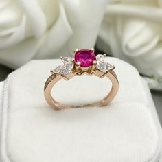 This beautiful ring is made from genuine 925 sterling silver with Rose Gold plating. Ring details- -The Main stone is a round cut 6mm Lab Created Ruby Stone -Side stones are 4mm by 2mm Marquise and 1mm Round simulated diamonds -Ring is casted in solid 925 sterling silver with Rose Gold plating ( Yellow Gold and White Rhodium plated also available, please check the drop down menu for more options) -The Total face height of the ring measures 7mms and the band width measures 1.5mms -Each ring is ha Pink Lab-created Ruby Promise Ring, Promise Ruby Ring With Center Stone In Rose Gold, Rose Gold Ruby Ring With Center Stone For Promise, Promise Ring With Center Stone, Rose Gold Sterling Silver Ruby Promise Ring, Rose Gold Promise Ring With Accent Stones, Rose Gold Rings With Accent Stones For Promise, Rose Gold Birthstone Ring With Accent Stones, Rose Gold Cluster Ring With Accent Stones For Promise