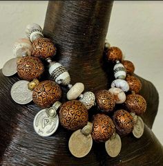 This is simply stunning and would look fabulous on any woman of color, or when worn during the warm - hot seasons with a tan! A double strand statement necklace features bold, chunky and heavy beads consisting of white magnesite rondelles, ornate copper repousse, inlaid white conch shells and large vintage Kuchi coins. Most of the beads are spaced with shiny silver tone metal balls. This adjusts from 19-22" and it does have some weight, so please know your tolerance for heavier pieces before you purchase. Finished with silver tone hardware, a lobster claw clasp, a 3" extender chain and a "Kat" charm lest you ever forget the designer! (me) Truly a piece any high-end socialite will covet! Bohemian Brown Beaded Bracelets With Silver Beads, Bohemian Polished Beaded Bracelets For Festivals, Bohemian Brown Beaded Necklaces For Festivals, Bohemian Brown Necklace With Silver Beads, Bohemian Beaded Bracelets With Polished Beads For Festivals, Brown Bohemian Beaded Necklaces For Festivals, Brown Bohemian Necklace With Silver Beads, Bohemian Beaded Bracelets With Large Beads For Festive Occasions, Bohemian Beaded Necklaces With Unique Variations