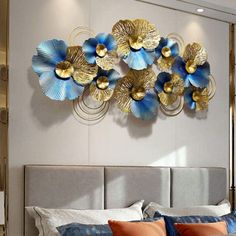 a bed with blue and gold flowers on the headboard in front of a window