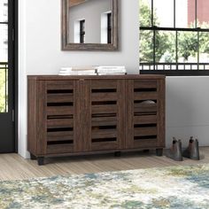 a room with a rug, mirror and wooden furniture on the floor in front of it