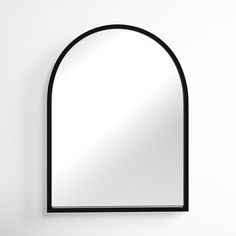 an arched mirror hanging on the wall above a sink in a room with white walls