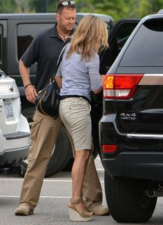 a man and woman are walking in the parking lot