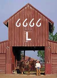 a man standing next to a horse in front of a barn