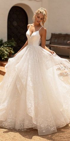 a woman in a white wedding dress standing outside