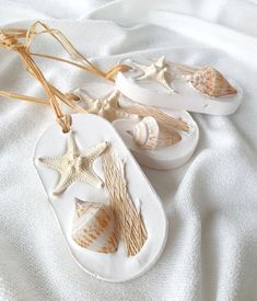 two white sandals with starfish and shells on them sitting on top of a bed