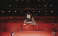 a woman is sitting in an empty theater