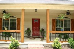 a red door sits on the front porch of a white house with columns and windows