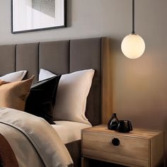 a bedroom with a bed, night stand and two lamps on either side of the headboard