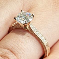 a close up of a person's hand with a diamond ring on their finger