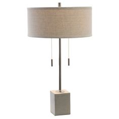 a lamp that is sitting on top of a table next to a light fixture with a beige shade