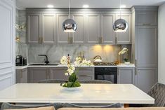 a kitchen with grey cabinets and white counter tops is seen in this image from the dining room