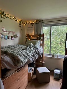 a bedroom with a bed, desk and window in it's corner next to a dresser