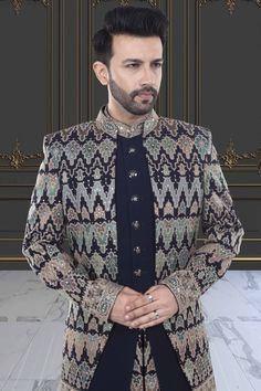 This Mens Sherwani is expertly designed with a unique open jacket style and adorned with intricate sequin and thread embroidery. Elevate your formal look with this exquisite piece, perfect for traditional events and special occasions. Enjoy the timeless elegance and sophisticated craftsmanship of this U2-S378 sherwani. Elegant Embroidered Jamawar Bandhgala, Festive Designer Suits With Intricate Embroidery, Bollywood Style Formal Outerwear With Resham Embroidery, Formal Bollywood Outerwear With Resham Embroidery, Traditional Formal Outerwear With Resham Embroidery, Traditional Resham Embroidered Formal Outerwear, Formal Embroidered Sherwani With Traditional Drape, Elegant Jamawar Bandhgala With Dabka Work, Elegant Bandhgala With Dabka Work In Jamawar