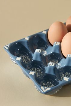 three eggs in a blue carton with white stars on them and one brown egg