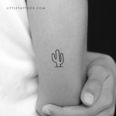 a small cactus tattoo on the arm