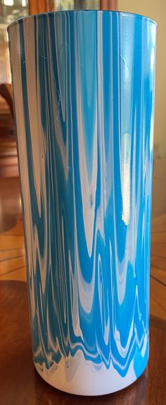 a blue and white vase sitting on top of a wooden table