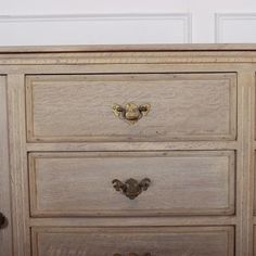 a wooden dresser with three drawers and knobs