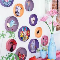 there are many plates on the wall with flowers in vases next to each other