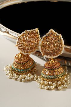 Les « Mishti - Statement Jhumkas » sont une fusion captivante de tradition et de style contemporain. Ces superbes boucles d'oreilles Jhumka s'inspirent de l'esthétique classique du patrimoine et présentent un design unique en forme de paan. Fabriqués avec une attention méticuleuse aux détails, ils témoignent d’une élégance intemporelle.

 Ornés d'une gamme de neuf pierres précieuses exquises, ces jhumkas sont une célébration de la couleur et du savoir-faire. Les pierres et les ornements multicol Elegant Chandbali Jhumkas For Navratri, Traditional Jhumkas For Eid Festivities, Traditional Jhumkas For Eid Festival, Temple Jewelry Style Jhumkas For Eid, Temple Jewelry Jhumkas For Festive Eid, Temple Jewelry Jhumkas For Festive Eid Occasions, Temple Jewelry Bridal Earrings For Eid Celebration, Traditional Jhumkas For Eid, Traditional Heavy Jhumkas For Festive Occasions