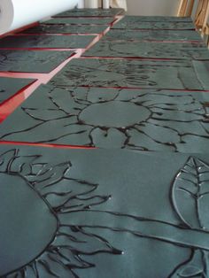 the floor is covered in black paper with red lines and flowers on it, as well as some chairs