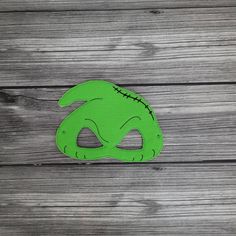 a green mask sitting on top of a wooden table