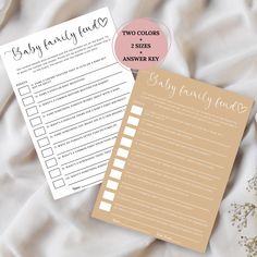 two baby shower checklist cards on top of a bed