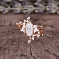 a close up of a ring on a wooden surface with flowers in the back ground