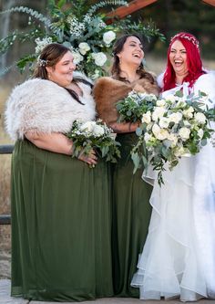 three women standing next to each other holding bouquets