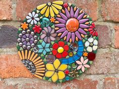 a colorful flower design on the side of a brick wall