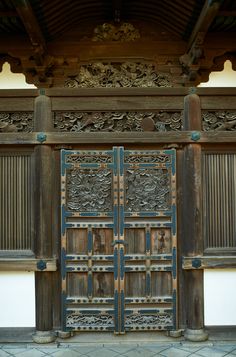 an old wooden door with carved designs on the front and side doors are open to let people know where they are going