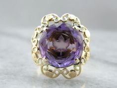 The center of this vintage gemstone is carved with the image of a maple leaf, shining from the center of the purple amethyst! We've set this gemstone into a filigree mounting that balances the unusual centerpiece perfectly! Metal: 14K Yellow Gold Gem: Amethyst 5.42 Carats Gem Measurements: 11.9 mm, Round Ring Size: 7 Unusual Centerpieces, Amethyst Cocktail Ring, Botanical Theme, Vintage Cocktail Ring, Maple Leafs, Round Rings, The Purple, Cocktail Ring, New Hampshire